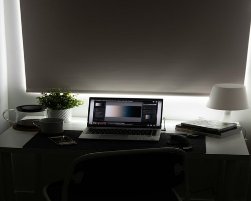Well-lit home office with desk lamp and window light
